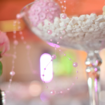 guirlande de perles rose posée sur le grand verre à martini
