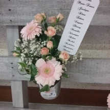 petit pot de fleurs en zinc accroché au plan de table avec le numéro des tables et le nom des invités