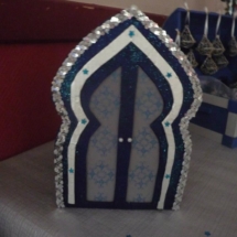 urne en forme de porte orientale fabriquée avec du carton avec autours le ruban de sequin argenté qui rappelle le photophore.