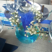 vase boule rempli d'eau coloré avec du colorant alimentaire de couleur bleu et avec du myosotis