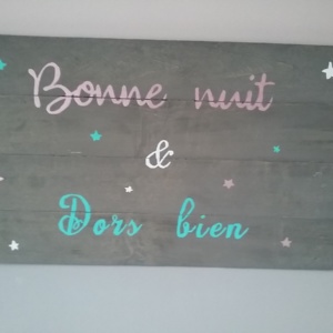 cadre en bois de palette pour chambre d'enfant peint en gris avec inscriptions aux couleurs douces