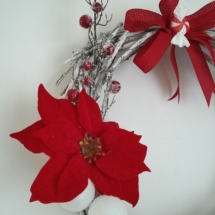 couronne de noël avec branches en bois et fleurs rouge