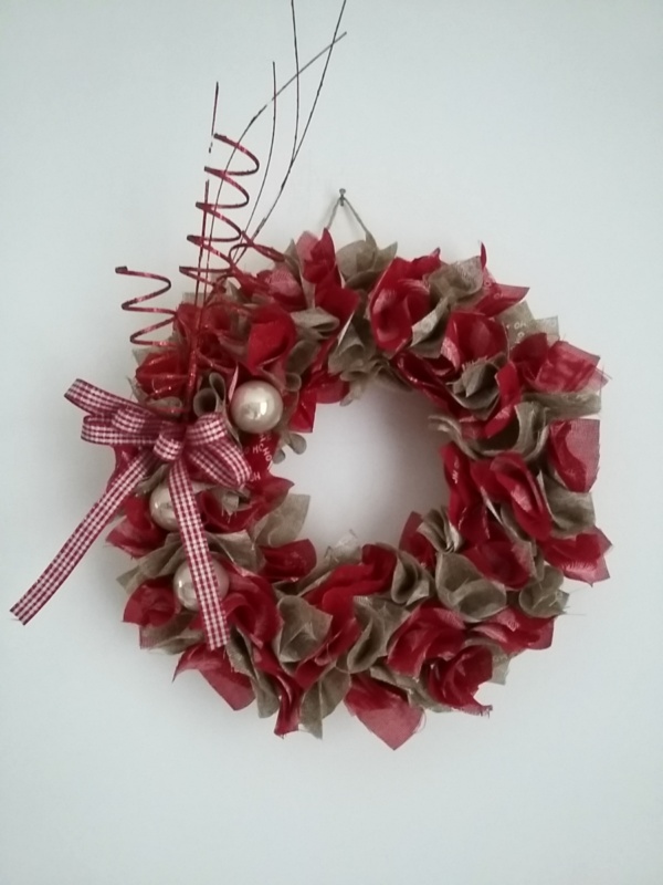 les décorations ( boules de noël, tiges pailletées rouge et noeud vichy ) ont été posées seulement d'un côté de la couronne