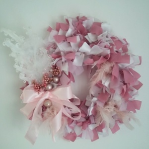 couronne de noël en tissus blanc et rose avec plume blanche, petites boules de noël rose et noeud en ruban satin rose pâle.