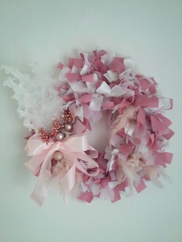 couronne de noël en tissus blanc et rose avec plume blanche, petites boules de noël rose et noeud en ruban satin rose pâle.