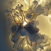 couronne de noël avec tissus blanc illuminée grâce à une guirlande à led