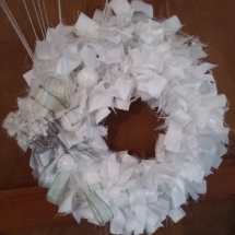 couronne de noël en tissus blanc avec fleurs de noël et noeud en ruban satin argenté