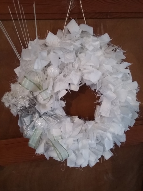 couronne de noël en tissus blanc avec fleurs de noël et noeud en ruban satin argenté