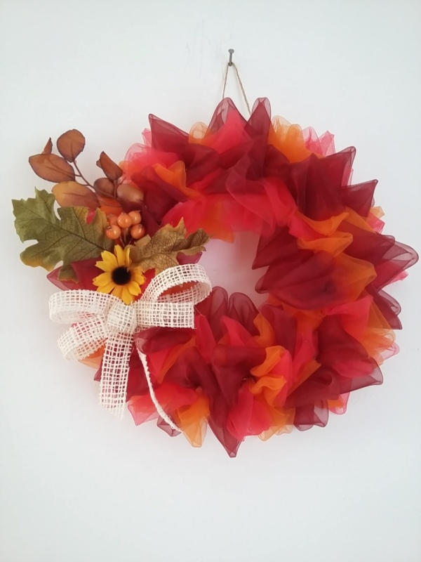 couronne de noël en tissus voilage couleur rouge et couleur orangé avec feuilles d'automne