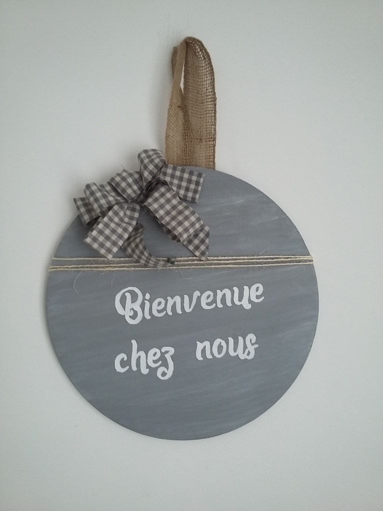 décor de porte en bois rond peint en couleur gris et une très légère patine blanche, un gros noeud Vichy gris, inscription blanche, le tout tenu par un ruban en toile de jute.