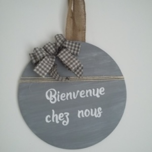 décor de porte en bois rond peint en couleur gris et une très légère patine blanche, un gros noeud Vichy gris, inscription blanche, le tout tenu par un ruban en toile de jute.