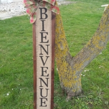 décoration pour une entrée de maison en bois de palette avec inscription bienvenue sur toile de jute et gros noeud rouge et vert