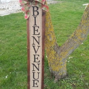 décoration pour une entrée de maison en bois de palette avec inscription bienvenue sur toile de jute et gros noeud rouge et vert