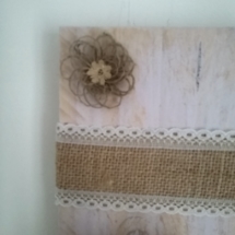 petite fleur en toile de jute posée sur le porte bougie mural