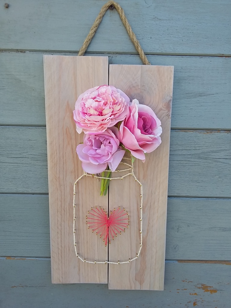 Pot de fleurs string art sur un cadre en bois brut teinte rosée légère
