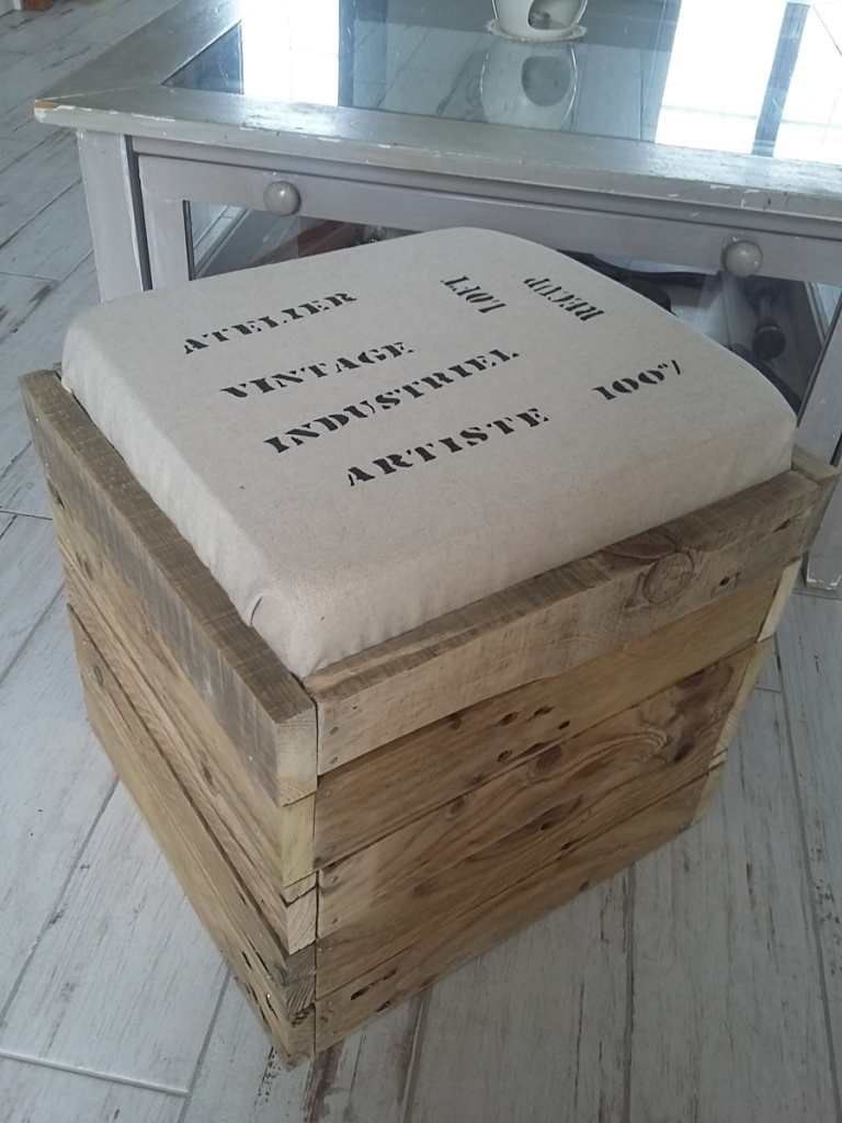 Pouf en bois de palette avec coussin en toile de jute et inscriptions thème industriel