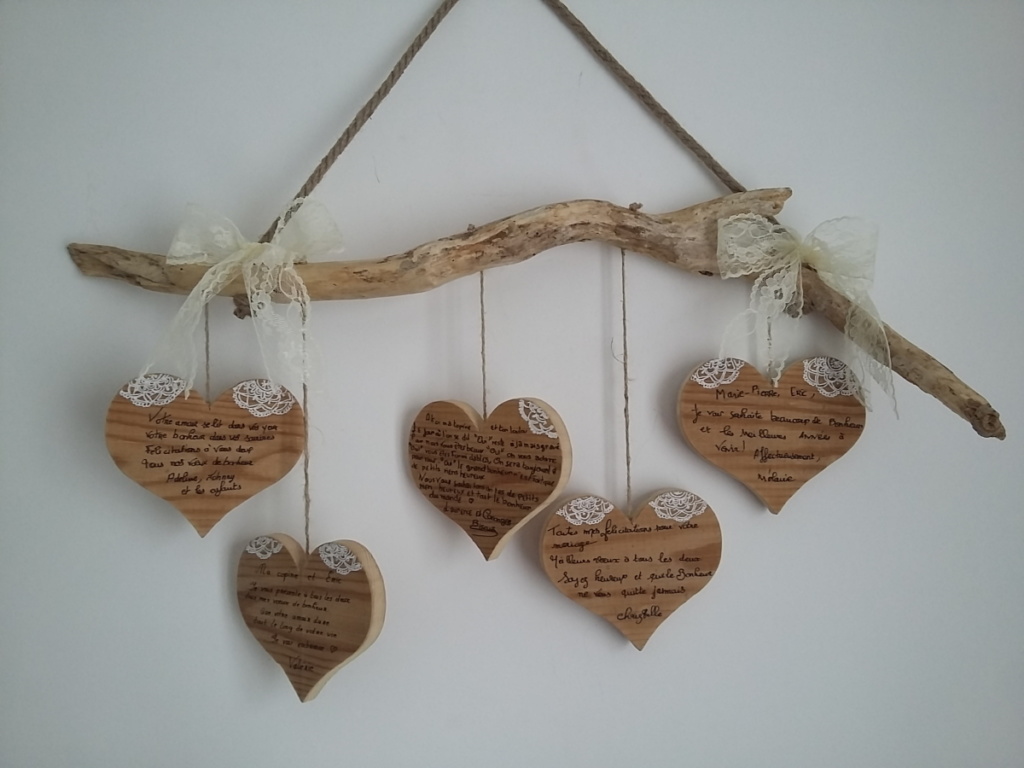 suspension en bois flotté avec messages de félicitations pour les mariés inscrits sur des coeurs en bois