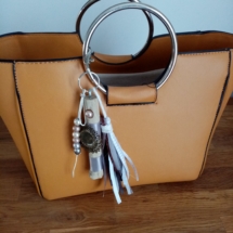 bijoux de sac couleur gris avec bois flotté, perles, ornement et pompons en tissus