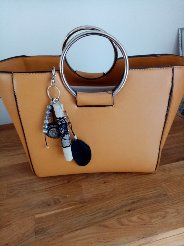 Bijoux de sac avec bois flotté, perles, ornement et plume noire.