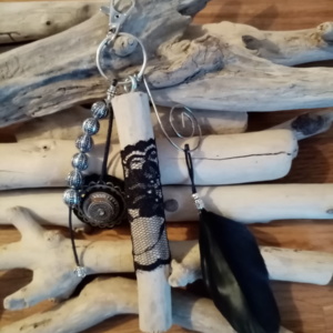 Bijoux de sac avec bois flotté, perles, ornement et plume noire.