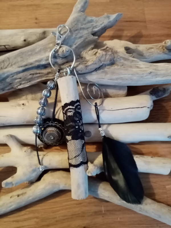 Bijoux de sac avec bois flotté, perles, ornement et plume noire.