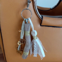 Bijoux de sac avec bois flotté, perles, ornement et pompon tissus, couleur or.