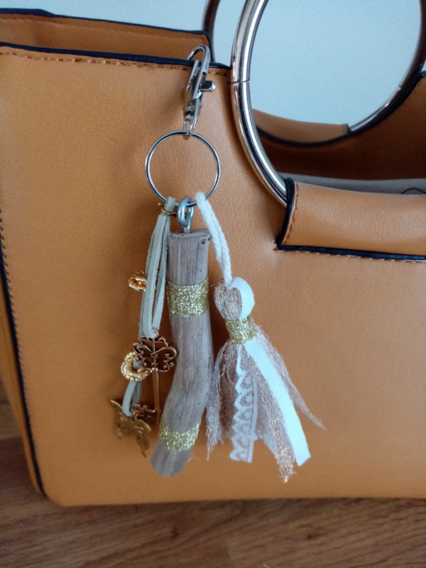 Bijoux de sac avec bois flotté, perles, ornement et pompon tissus, couleur or.