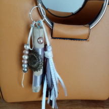 bijoux de sac couleur gris avec bois flotté, perles, ornement et pompons en tissus