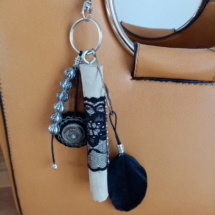 Bijoux de sac avec bois flotté, perles, ornement et plume noire.
