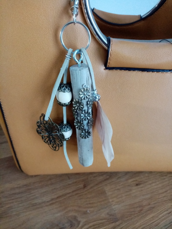 Bijoux de sac avec bois flotté, perles, ornement en laiton et plume rose très clair