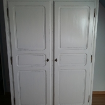 armoire de la chambre de bébé restaurée couleur blanc et patinée à la bougie