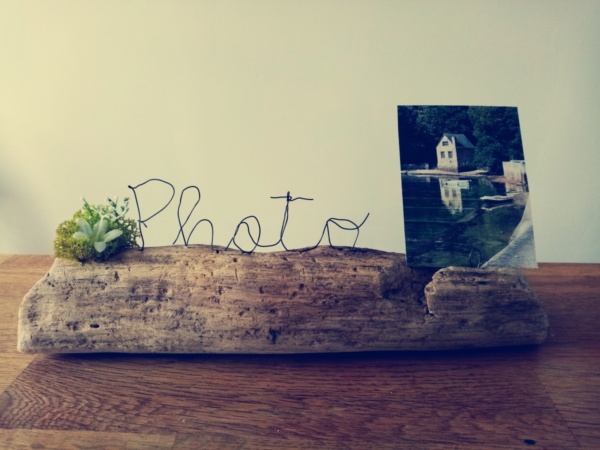 Porte photo avec écriture en fil de fer posé sur du bois flotté