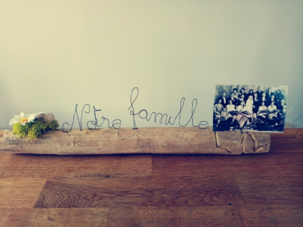 Porte photo avec écriture en fil de fer, notre famille, posé sur du bois flotté