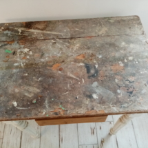 Ancienne table avec de la peinture et du très vieux tissus collé dessus .