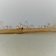 Décoration pour un atelier couturière fabriqué avec du fil de kraft armé posé délicatement sur une branche de bois flotté.