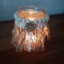 Petit bougeoir avec corde de jute en macramé, perles de bois et dentelle, illuminé avec une bougie chauffe plat