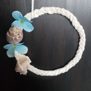 Petite couronne de macramé tressé avec un coquillage et des petites fleurs