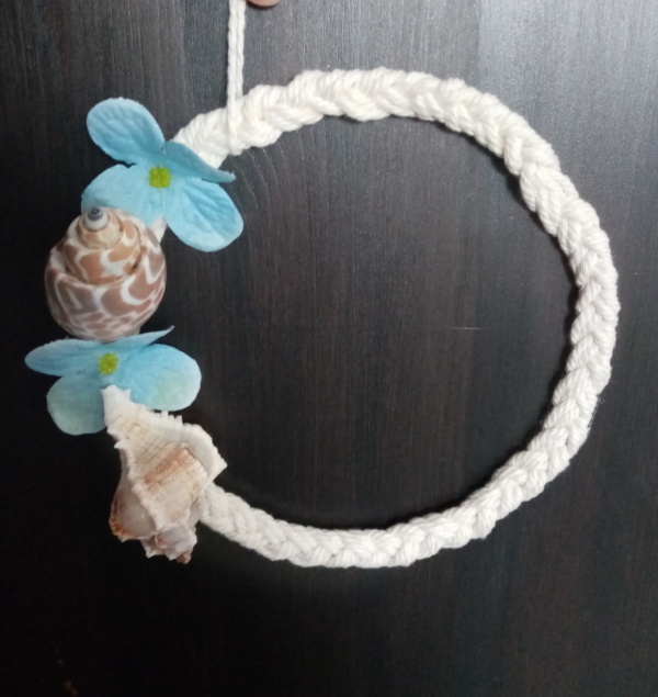 Petite couronne de macramé tressé avec un coquillage et des petites fleurs