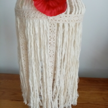 Vase bouteille entouré de macramé et agrémenté d'une fleur de coquelicot