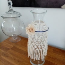 Vase bouteille entouré de macramé et agrémenté d'une fleur en bois
