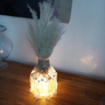 Petit vase en macramé avec noeud en toile de jute et fleurs de pampa illuminé par une guirlande à led
