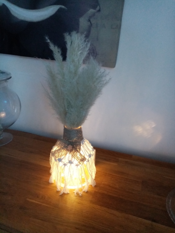 Petit vase en macramé avec noeud en toile de jute et fleurs de pampa illuminé par une guirlande à led