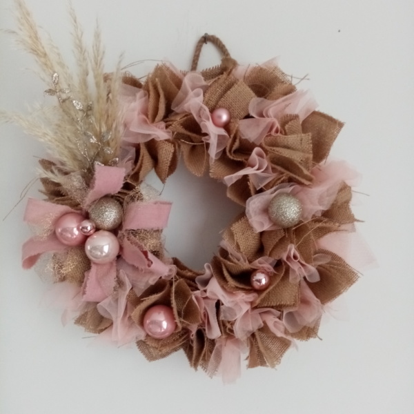 Couronne de noël en toile de jute et tissus voile couleur rose pastel avec fleur de pampa, boules de noël rose et or pailleté