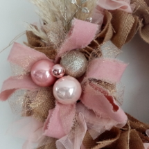 Décorations de noël couleur rose et or pailleté sur couronne en toile de jute et tissus voile rose pastel