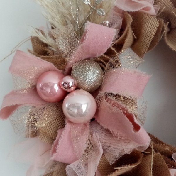 Décorations de noël couleur rose et or pailleté sur couronne en toile de jute et tissus voile rose pastel