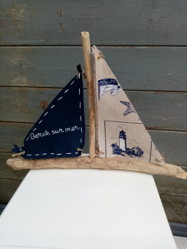Bateau en bois flotté avec deux voiles. Une voile tissus bleu marine avec inscription en broderie blanche " Berck sur mer" et une autre voile couleur crème et des imprimés bleu marine