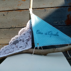 Bateau en bois flotté avec deux voiles. Une voile en tissus bleu clair et tout petits pois blanc et inscription " Côte d'opale" en broderie bleu ciel et une voile en véritable dentelle de Calais