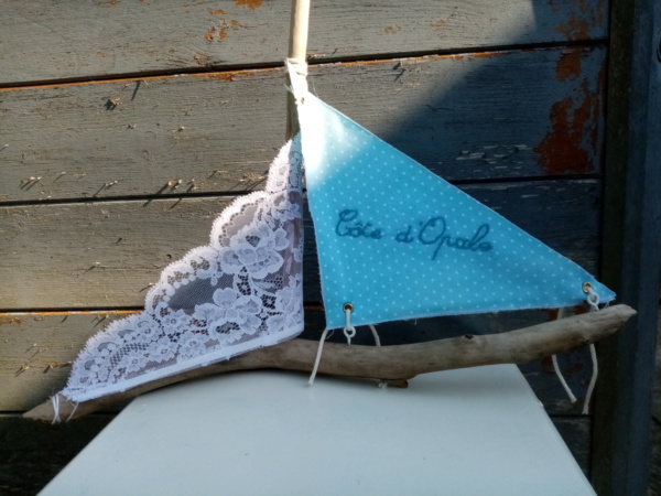 Bateau en bois flotté avec deux voiles. Une voile en tissus bleu clair et tout petits pois blanc et inscription " Côte d'opale" en broderie bleu ciel et une voile en véritable dentelle de Calais