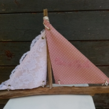 Bateau en bois flotté avec deux voiles. Une voile en tissus rose et tout petits pois blanc avec inscription "Côte d'opale" en broderie rose et une autre voile avec de la véritable dentelle de Calais.