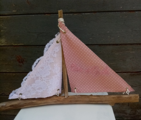 Bateau en bois flotté avec deux voiles. Une voile en tissus rose et tout petits pois blanc avec inscription "Côte d'opale" en broderie rose et une autre voile avec de la véritable dentelle de Calais.